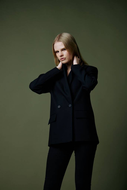 Full-length portrait of a blonde in a classic suit posing on a green background in the studio. High quality photo - Photo, Image