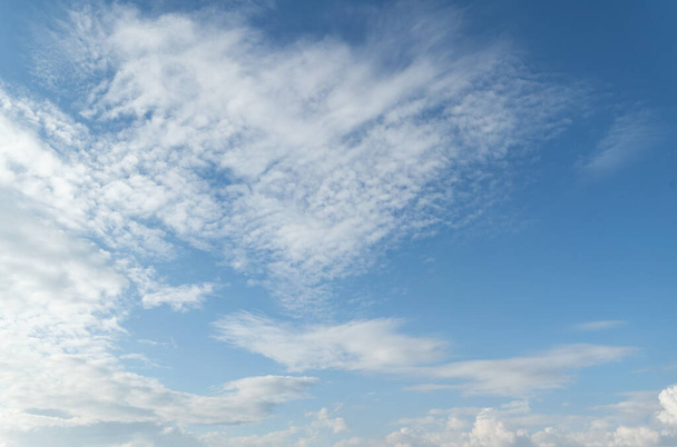 Синий и голубой градиент цвета неба и белых облаков, плавающих в воздухе. Потрясающий вид на гармонию кучевого и ясного неба. - Фото, изображение