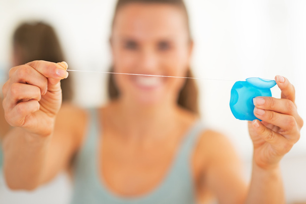 Closeup on happy young woman showing dental floss - Foto, immagini