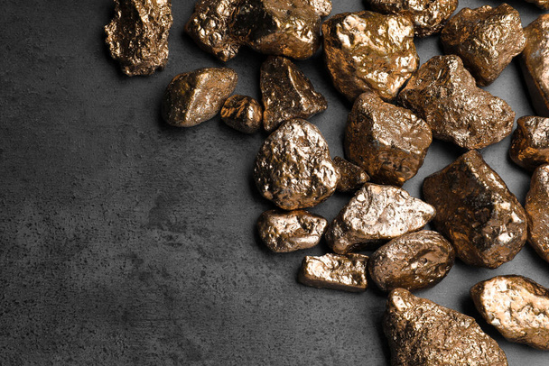 Pile of gold nuggets on grey table, flat lay. Space for text - Fotoğraf, Görsel