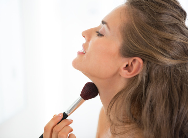 Portrait of young woman applying makeup - Фото, зображення