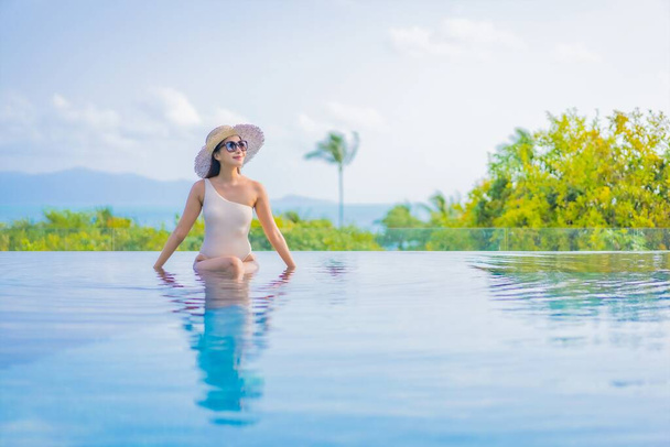 Портрет красива молода азіатка насолоджується відкритим басейном з видом на море у подорожі відпусткою
 - Фото, зображення
