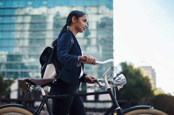 Keep going and youll get there. a young businesswoman traveling with a bicycle through the city - Fotoğraf, Görsel