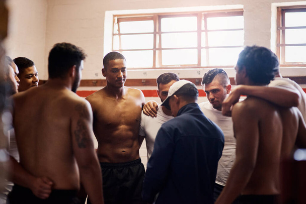 Forget sports team, theyre a family. a rugby coach addressing his team players in a locker room - Фото, изображение