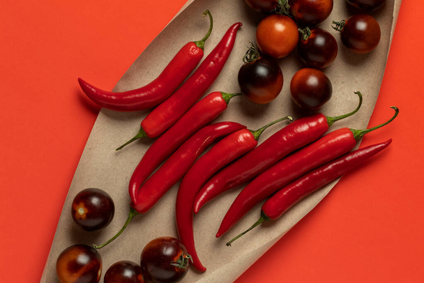 Black strawberry tomatoes and red hot chili peppers. Top view. - Valokuva, kuva