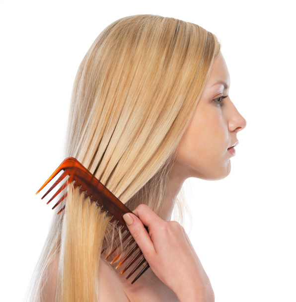 Young woman combing hair - Foto, Imagem