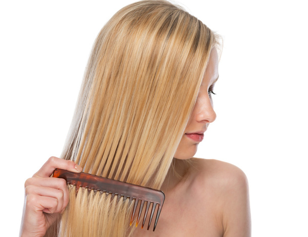 Young woman combing hair - Φωτογραφία, εικόνα