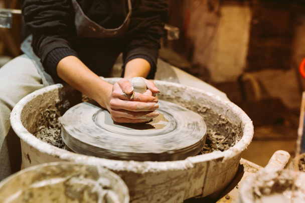 female hands of pottery master close-up work behind potter's wheel. Master class for manufacture of handcrafted ceramic products - 写真・画像