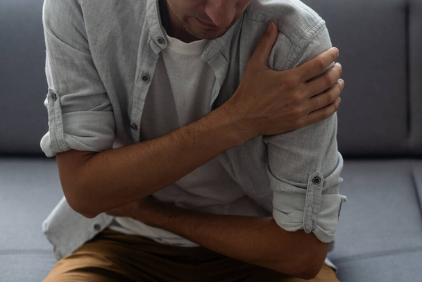 Shoulder pain. The mans shoulder hurts. A Band-Aid - Photo, Image