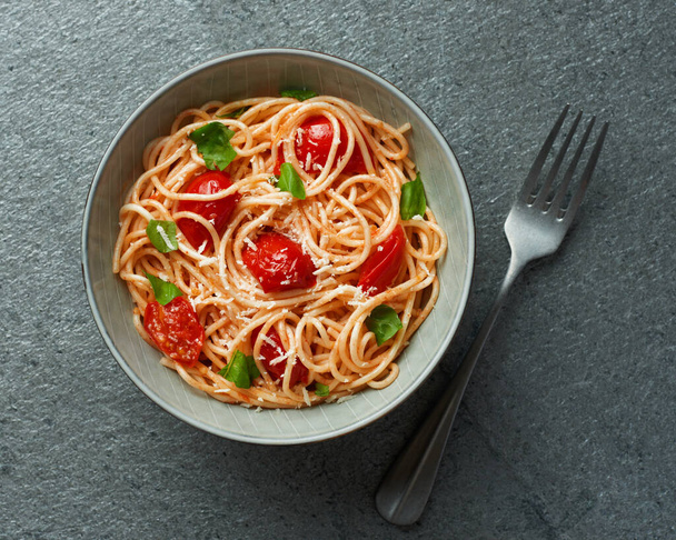 Spaghetti with cherry tomatoes top view on grey slate background - Fotoğraf, Görsel