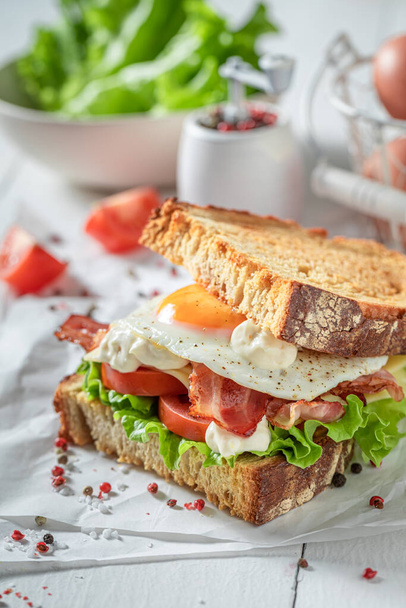 Homemade and crunchy toasted sandwich with bacon, mayonnaise and egg. British breakfast. - Fotoğraf, Görsel