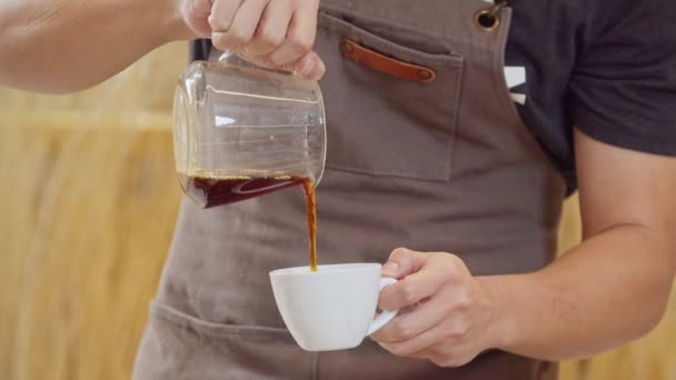 A professional barista pours the brewed coffee into a cup. Slow Motion 4K DCI (The submitted footage is a grouping shooting arrangement) - Video