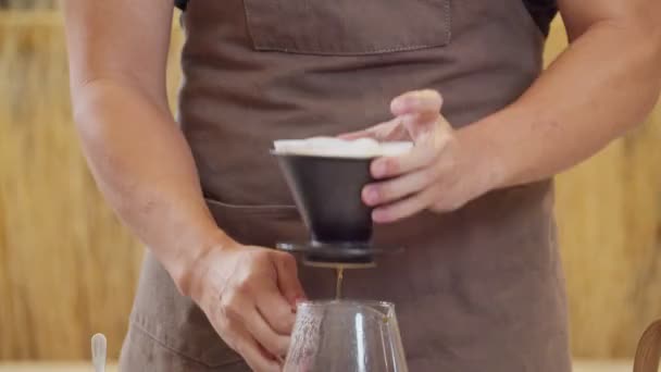 A professional barista pours water over the coffee grounds in the filter as a manual process. CU Shot, 4k Slow Motion video (The submitted footage is a grouping shooting arrangement) - Felvétel, videó
