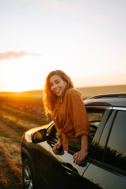 Towards adventure! Young woman is resting and enjoying the trip in the car.  Lifestyle, travel, tourism, nature, active life. - Photo, Image