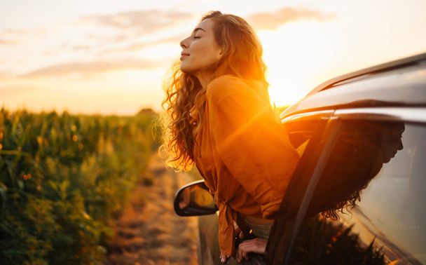 Towards adventure! Young woman is resting and enjoying the trip in the car.  Lifestyle, travel, tourism, nature, active life. - Photo, Image