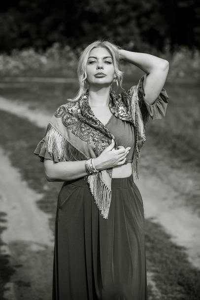 Ethnic gypsy woman posing in boho style clothes at nature. Outdoor fashion. Concept of ethnos style  - Foto, imagen