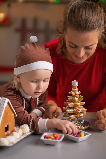 Happy mother and baby making cookie christmas tree - Foto, Imagem