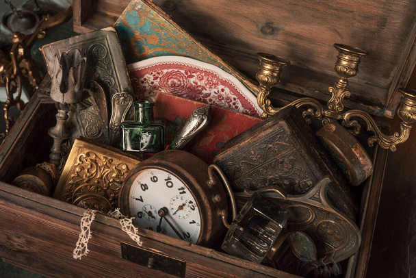 Antique treasures in a wooden box at a flea market - Foto, Imagen