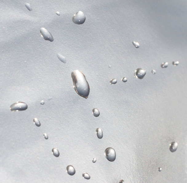 drops of water on metallic waterproof paper. liquid texture wallpaper. - Photo, image