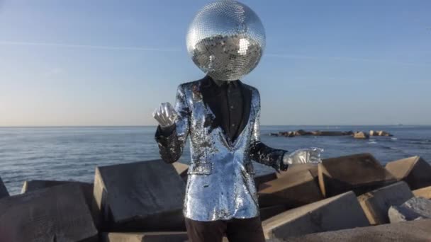 Mr disco man with a shiny mirror ball head next to the sea - Video