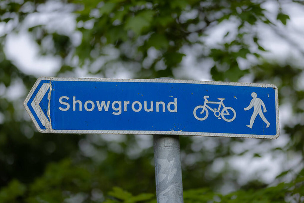 Синій дорожній знак говорить про майданчик і піктограми велосипеда, пішохода і стріли
 - Фото, зображення