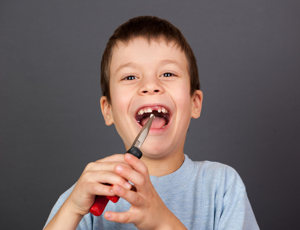 Мальчик имитирует удаление зубов плоскогубцами
 - Фото, изображение