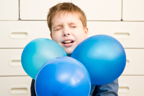 Παγκόσμιο θέμα εορτασμού του αυτισμού. Αγόρι με ένα μπλε μπαλόνι. - Φωτογραφία, εικόνα