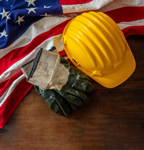 Labor day. Construction helmet and USA Flag on wood, top view, copy space. US holiday celebration - Photo, image