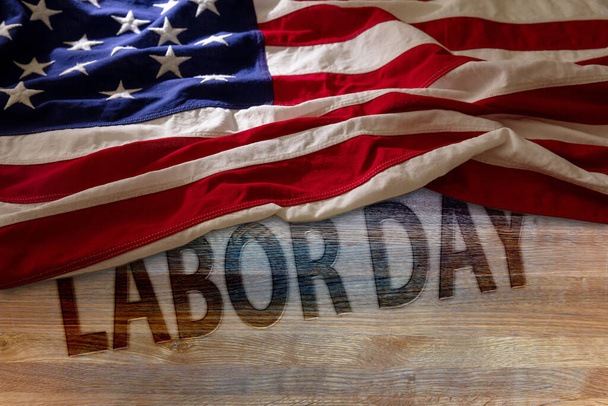 LABOR DAY text and USA Flag on wooden table, above view. United States holiday celebration background - Foto, immagini