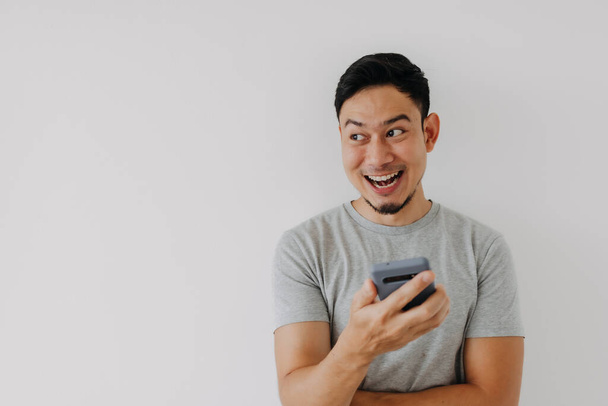Wow and surprise face asian man use smartphone with copy space of advertisement. - Photo, image