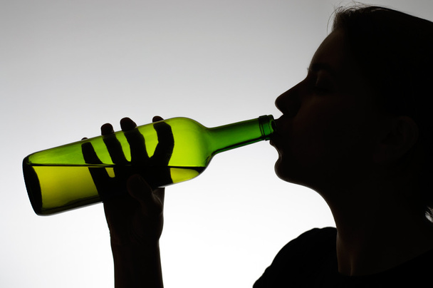 Alcoholic woman drinking from a bottle - Fotografie, Obrázek