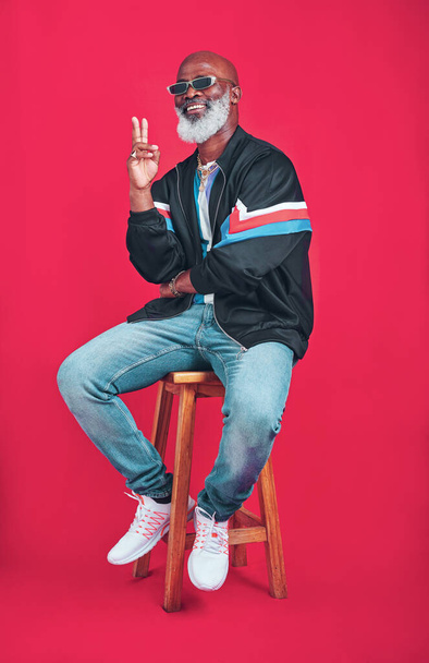 Be good to life and itll be good to you. Studio shot of a senior man wearing retro attire while posing against a red background - 写真・画像