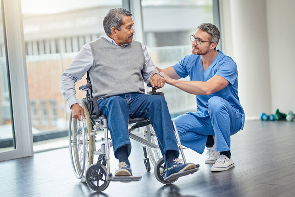 How are you finding your new wheelchair. a nurse helping a senior man in a wheelchair - Foto, Imagem