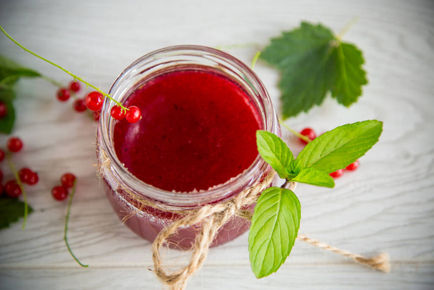 sweet summer jam from ripe red currants in a jar on a wooden table - Zdjęcie, obraz