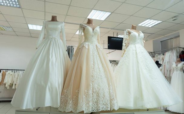 Three chic wedding dresses on mannequins. Three different models of beautiful wedding dresses. - Photo, image