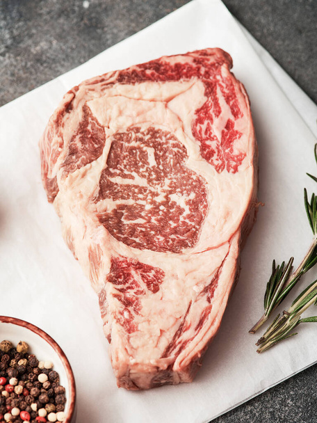 Raw entrecote on white paper. Preparing raw beef steak for barbecue grill - Foto, immagini