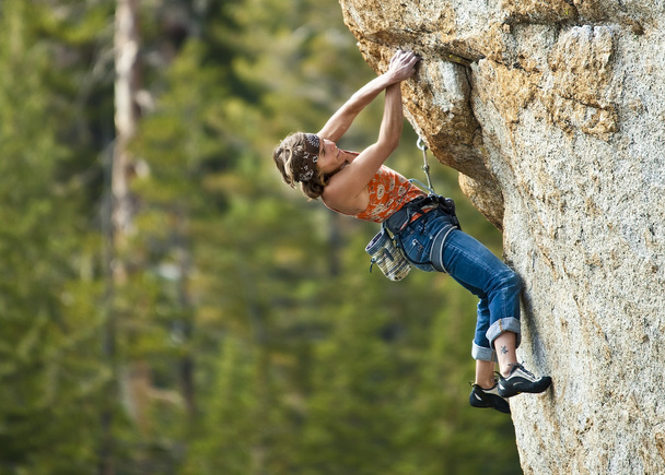 θηλυκό ορειβάτης σκαρφαλωμένο σε ένα βράχο. - Φωτογραφία, εικόνα