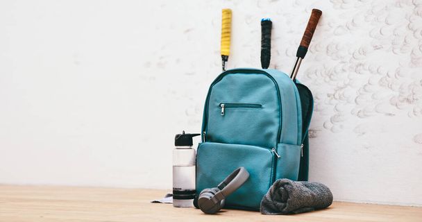 Get your gear together, weve got a game to play. a sports bag and other items in an empty squash court - Фото, изображение