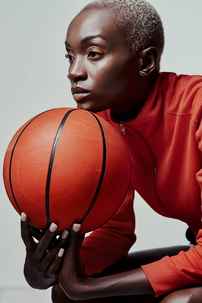 Better be ready for what shes about to bring. Studio shot of an attractive young woman playing basketball against a grey background - Photo, image