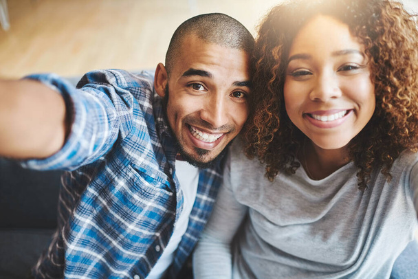 Happy couple taking selfies as home owners, bonding or enjoying new real estate purchase. Portrait of smiling or proud man and woman celebrating and capturing memory picture as home investors. - 写真・画像