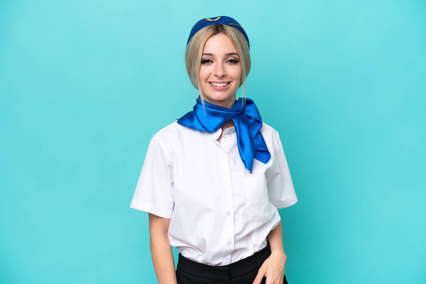 Airplane blonde stewardess woman isolated on blue background laughing - Фото, изображение