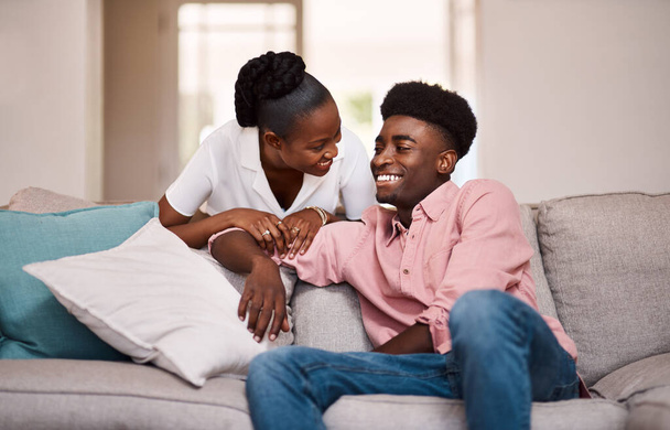 Can I get you anything from the kitchen. a happy young couple relaxing on the sofa at home - Foto, Imagen