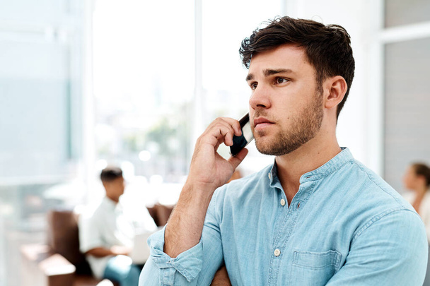 Im not quite happy with this news... a young businessman talking on a cellphone in an office - Foto, Imagem