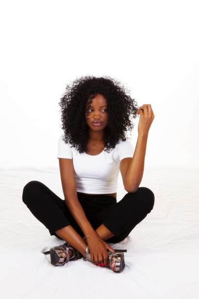 Młody Afroamerykanin nastolatek siedzi patrząc na włosy - Zdjęcie, obraz
