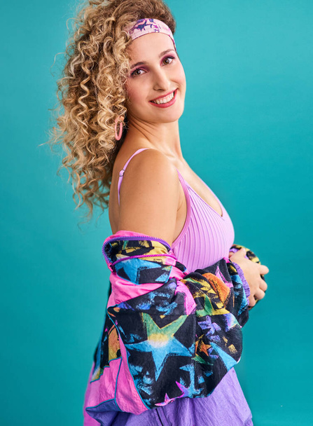 I came to spread some 80s vibes. Studio shot of a beautiful young woman wearing a 80s outfit - Photo, image