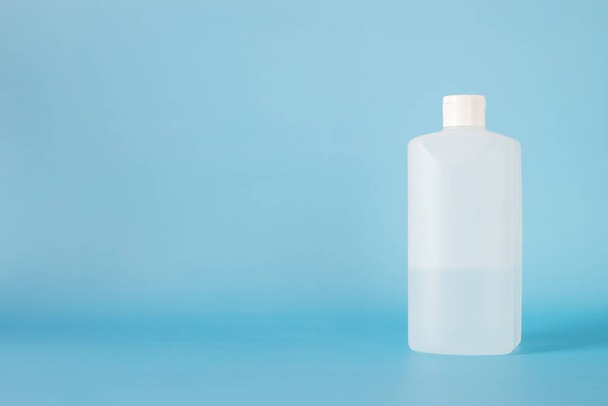 white plastic bottle for hand sanitizer on blue background. - 写真・画像
