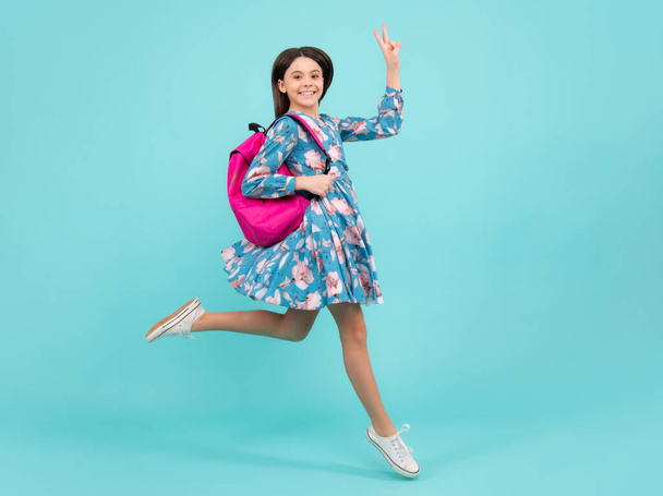 School teen girl in with backpack. Run and jump. Teenager student on isolated background. Kids learning, education, studying and knowledge. Happy teenager, positive and smiling emotions - Photo, image