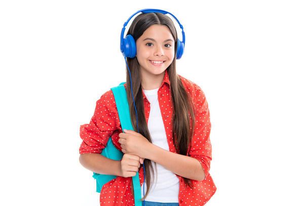 School girl, teenager student in headphones on white isolated studio background. Music school concept. Portrait of happy smiling teenage child girl - Photo, image