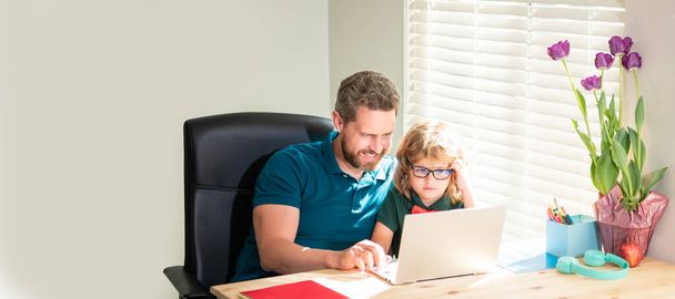 Прапор вчителя і школяра з ноутбуком вдома, назад до школи. батько і син в окулярах використовують комп'ютер вдома. сімейний блог. ботанік хлопчик
. - Фото, зображення