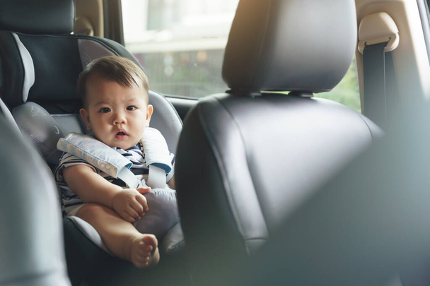 Adorable Little Asian baby boy in safety car seat, Happy small toddler travel by car with family. - 写真・画像